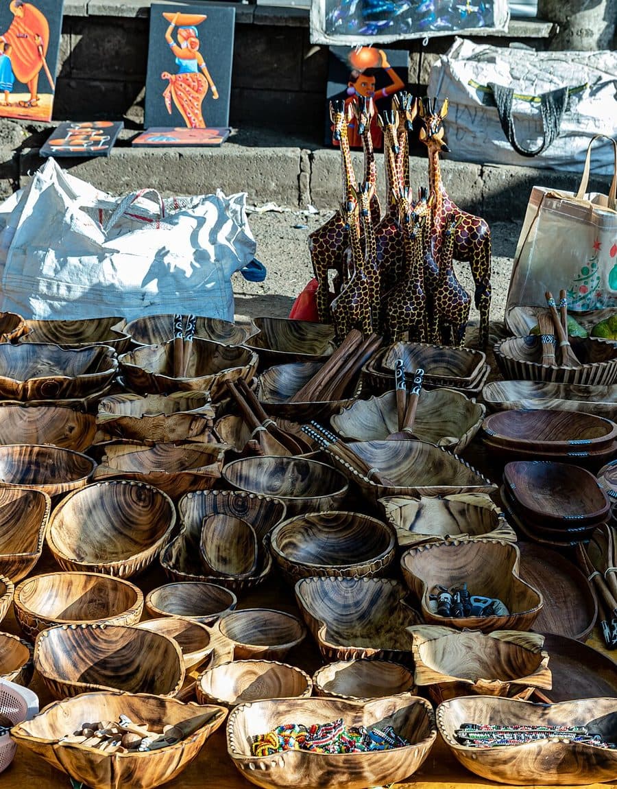 Hand-carved bowls, utensils and beadwork laid out at a Nairobi market